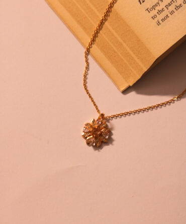 Blooming sparkle in gold-tone—a delicate floral pendant necklace that whispers elegance with every petal