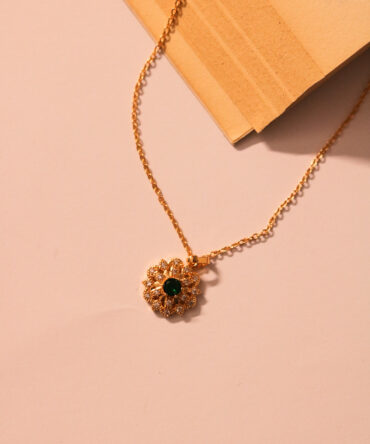 Emerald blooms on golden prose—a necklace that reads like poetry